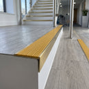 Solid brass stair nosing, 59.5mm tread with a 30mm raked-back front, in Satin Brass finish with Gold Castellated insert, fitted to a staircase