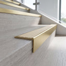 Solid brass stair nosing, 59.5mm tread with a 30mm raked-back front, in Satin Brass finish with Ivory Castellated insert, fitted to a staircase