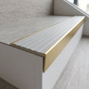 Solid brass stair nosing, 59.5mm tread with a 30mm raked-back front, in Satin Brass finish with Light Grey Castellated insert, fitted to a staircase