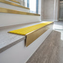 Solid brass stair nosing, 59.5mm tread with a 30mm raked-back front, in Satin Brass finish with Yellow Castellated insert, fitted to a staircase