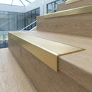 Solid brass stair nosing 62mm ribbed tread in satin brass finish fitted on a step edge