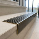 Solid brass stair nosing 71mm raked back in antique brass with antique brass insert fitted on a limestone office staircase