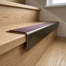 Solid brass stair nosing 71mm raked back in antique brass with claret castellated insert fitted on an oak domestic hallway staircase
