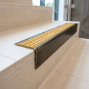 Solid brass stair nosing 71mm raked back in antique brass with gold castellated insert fitted on a limestone office staircase