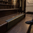 Solid brass stair nosing 71mm raked back in antique brass with granite castellated insert fitted on a dark oak hotel stairwell