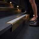 Solid brass stair nosing 71mm raked back in antique brass with nimbus castellated insert fitted on a slate restaurant staircase