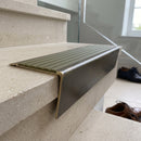 Solid brass stair nosing 71mm raked back in antique brass with olive castellated insert fitted on a limestone office staircase