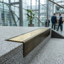 Solid brass stair nosing 71mm raked back in antique brass with polished brass insert fitted on a granite atrium staircase