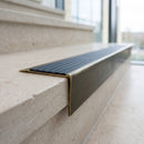 Solid brass stair nosing 71mm raked back in antique brass with regency castellated insert fitted on a limestone office staircase