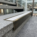 Solid brass stair nosing 71mm raked back in antique brass with white castellated insert fitted on a granite atrium staircase