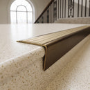 Solid brass stair nosing 71mm raked back in antique bronze with antique brass insert fitted on a limestone office staircase