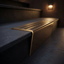 Solid brass stair nosing 71mm raked back in antique bronze with antique bronze insert fitted on a dark oak hotel stairwell
