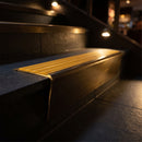 Solid brass stair nosing 71mm raked back in antique bronze with gold castellated insert fitted on a limestone office staircase