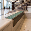Solid brass stair nosing 71mm raked back in antique bronze with jade castellated insert fitted on a vinyl plank school staircase