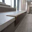 Solid brass stair nosing 71mm raked back in antique bronze with light grey castellated insert fitted on a granite atrium staircase