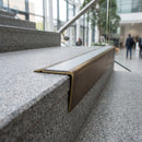 Solid brass stair nosing 71mm raked back in antique bronze with light grey smooth textured insert fitted on an oak domestic hallway staircase
