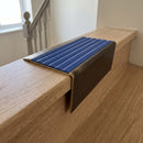 Solid brass stair nosing 71mm raked back in antique bronze with mid blue castellated insert fitted on a terrazzo museum foyer staircase