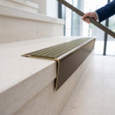 Solid brass stair nosing 71mm raked back in antique bronze with olive castellated insert fitted on a limestone office staircase
