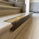 Solid brass stair nosing 71mm raked back in antique bronze with polished brass insert fitted on a granite atrium staircase