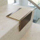 Solid brass stair nosing 71mm raked back in antique bronze with porth stone castellated insert fitted on a terrazzo museum foyer staircase