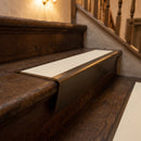 Solid brass stair nosing 71mm raked back in antique bronze with porth stone smooth textured insert fitted on a slate restaurant staircase