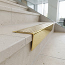 Solid brass stair nosing 71mm raked back in polished brass with antique brass insert fitted on a limestone office staircase