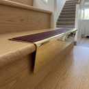 Solid brass stair nosing 71mm raked back in polished brass with claret castellated insert fitted on an oak domestic hallway staircase
