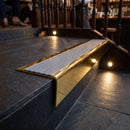 Solid brass stair nosing 71mm raked back in polished brass with flint castellated insert fitted on a slate restaurant staircase