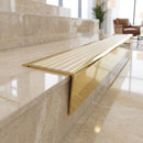 Solid brass stair nosing 71mm raked back in polished brass with ivory castellated insert fitted on a porcelain tiled hotel lobby staircase