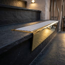 Solid brass stair nosing 71mm raked back in polished brass with nimbus castellated insert fitted on a slate restaurant staircase