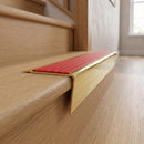Solid brass stair nosing 71mm raked back in polished brass with poppy castellated insert fitted on an oak domestic hallway staircase