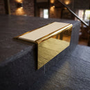 Solid brass stair nosing 71mm raked back in polished brass with porth stone smooth textured insert fitted on a slate restaurant staircase