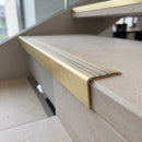 Solid brass stair nosing 71mm raked back in satin brass with antique brass insert fitted on a limestone office staircase