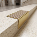 Solid brass stair nosing 71mm raked back in satin brass with fawn castellated insert fitted on a terrazzo museum foyer staircase