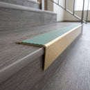 Solid brass stair nosing 71mm raked back in satin brass with jade castellated insert fitted on a vinyl plank school staircase