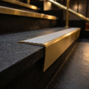 Solid brass stair nosing 71mm raked back in satin brass with nimbus castellated insert fitted on a slate restaurant staircase