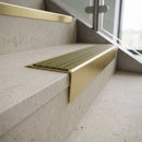 Solid brass stair nosing 71mm raked back in satin brass with olive castellated insert fitted on a limestone office staircase