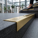 Solid brass stair nosing 71mm raked back in satin brass with polished brass insert fitted on a granite atrium staircase
