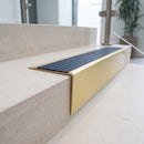 Solid brass stair nosing 71mm raked back in satin brass with regency castellated insert fitted on a limestone office staircase