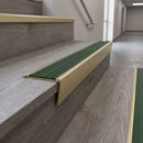 Solid brass stair nosing 71mm raked back in satin brass with spruce castellated insert fitted on a vinyl plank school staircase