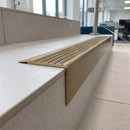 Solid Brass Stair Nosing 71mm Tread Square Front Slimline in Antique Brass finish with Antique Brass insert fitted on a modern office reception staircase with porcelain tile treads