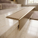 Solid Brass Stair Nosing 71mm Tread Square Front Slimline in Antique Brass finish with Fawn Castellated insert fitted on a hotel lobby staircase with cream marble treads