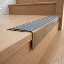Solid Brass Stair Nosing 71mm Tread Square Front Slimline in Antique Brass finish with Flint Castellated insert fitted on a residential oak staircase