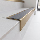 Solid Brass Stair Nosing 71mm Tread Square Front Slimline in Antique Brass finish with Nimbus Castellated insert fitted on a modern office reception staircase with porcelain tile treads