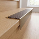 Solid Brass Stair Nosing 71mm Tread Square Front Slimline in Antique Brass finish with Peat Castellated insert fitted on a residential oak staircase