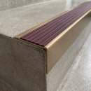 Solid Brass Stair Nosing 71mm Tread Square Front Slimline in Antique Brass finish with Regency Castellated insert fitted on a retail store staircase with polished concrete treads