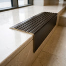 Solid Brass Stair Nosing 71mm Tread Square Front Slimline in Antique Bronze finish with Antique Bronze insert fitted on a hotel lobby staircase with cream marble treads
