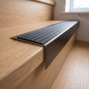 Solid Brass Stair Nosing 71mm Tread Square Front Slimline in Antique Bronze finish with Black Castellated insert fitted on a residential oak staircase