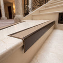 Solid Brass Stair Nosing 71mm Tread Square Front Slimline in Antique Bronze finish with Fawn Castellated insert fitted on a hotel lobby staircase with cream marble treads