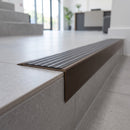 Solid Brass Stair Nosing 71mm Tread Square Front Slimline in Antique Bronze finish with Nimbus Castellated insert fitted on a modern office reception staircase with porcelain tile treads